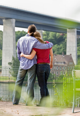 Man and woman looking out at the riverの写真素材