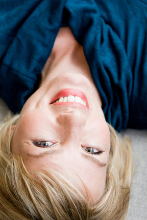 Woman lying on sofa looking at viewerの写真素材
