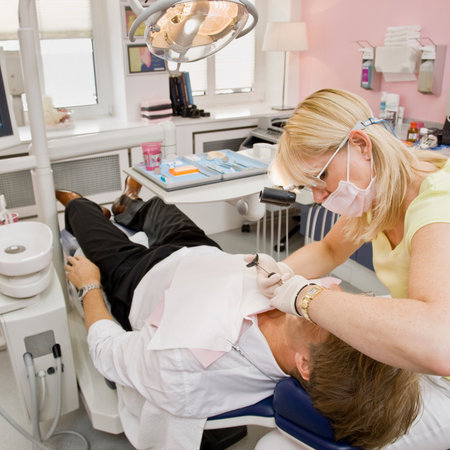 Female dentist working on a male patientの写真素材