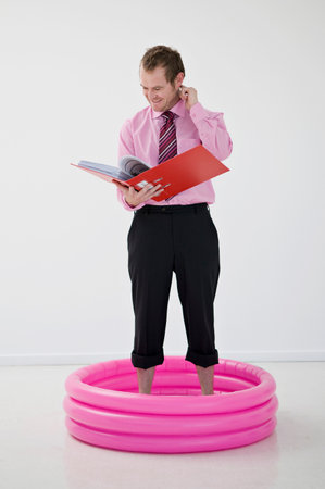 Business man standing in paddling poolの写真素材
