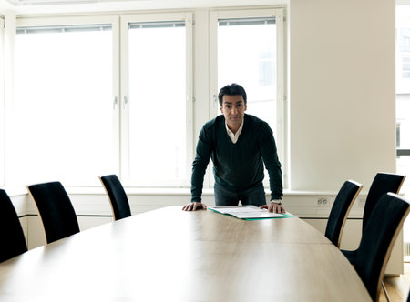 Business man by conference tableの写真素材