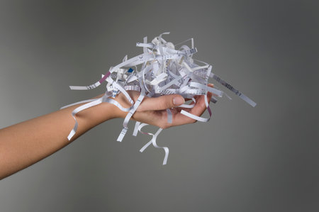 Female hand holding shredded paperの写真素材