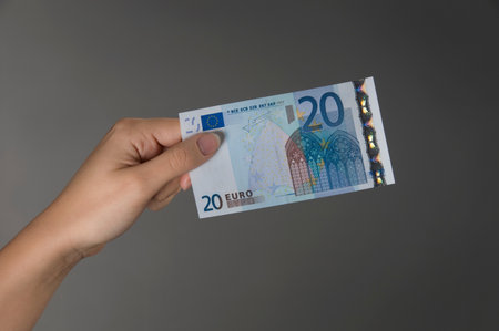 Female hand holding a Euro banknoteの写真素材