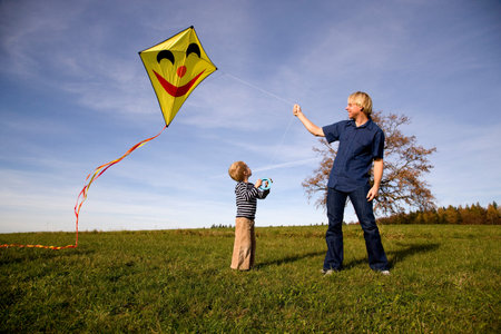 Boy and father fly a Kiteの写真素材