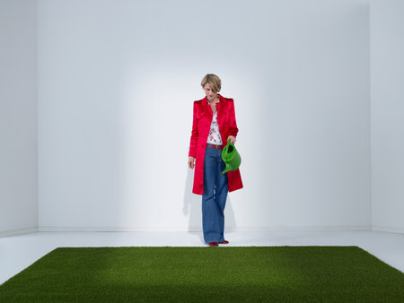 Woman in green office watering turfの写真素材