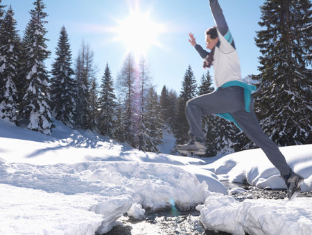Man jumping across streamの写真素材