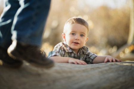 Young boy climbing on logの写真素材