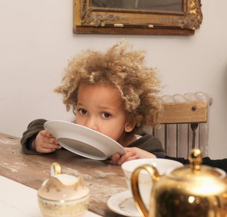 Young boy licking plateの写真素材