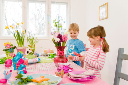 girl and boy admire easter tableの写真素材