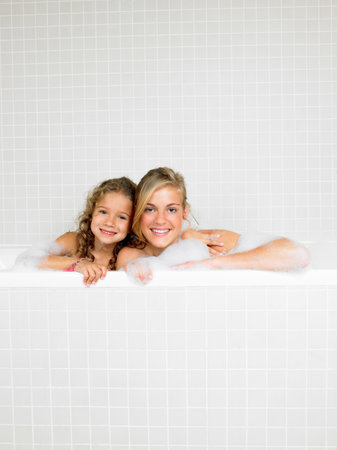 Sisters in a bath, foamの写真素材