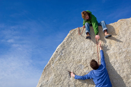Climber helping fellow climberの写真素材