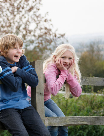 Boy and girl on fenceの写真素材