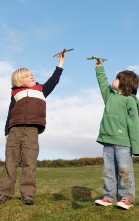 Boys with toy planes in fieldの写真素材