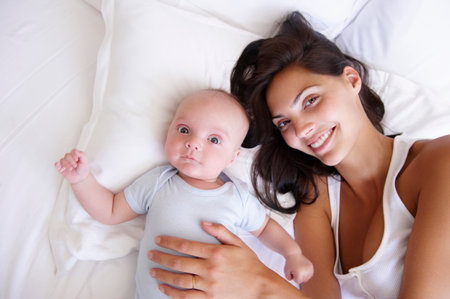 Woman with her baby, in bedの写真素材