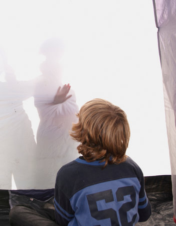 Boy looking at shadows in tentの写真素材