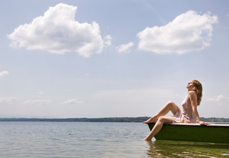 woman sitting on boat on lakeの写真素材