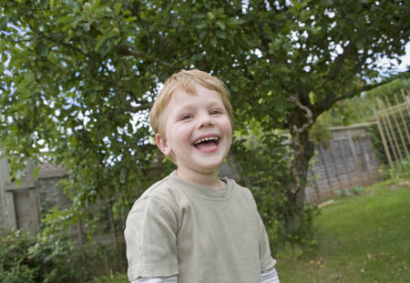 boy laughing in gardenの写真素材