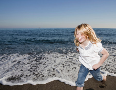 Young girl running on beachの写真素材