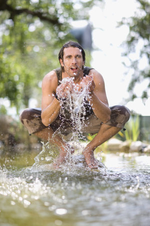 Man sitting in a riverの写真素材