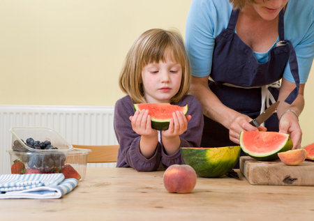 girl and mother with watermelon slicesの写真素材