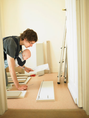Man with baby building furnitureの写真素材
