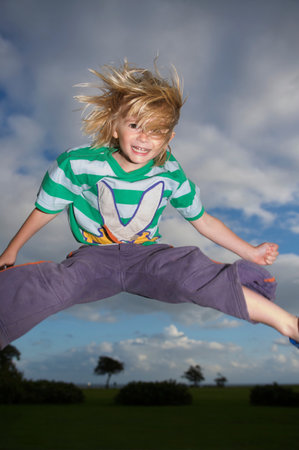 Young boy jumping into the airの写真素材