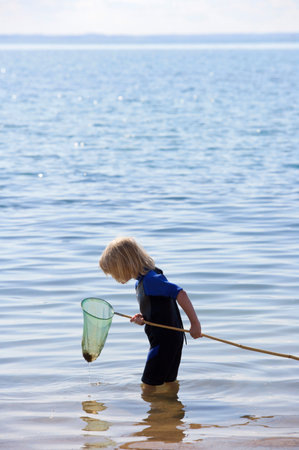 Boy look into a fishing netの写真素材
