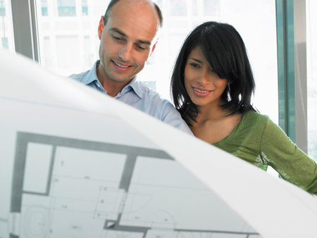 Man and woman looking at blue printsの写真素材