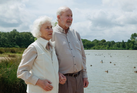 Elderly man holding elderly woman's handの写真素材