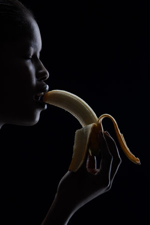 Woman eating bananaの写真素材