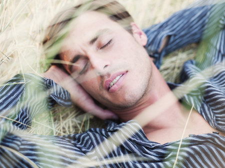 man lying in grass relaxingの写真素材