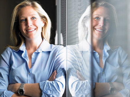 Woman against window, smilingの写真素材