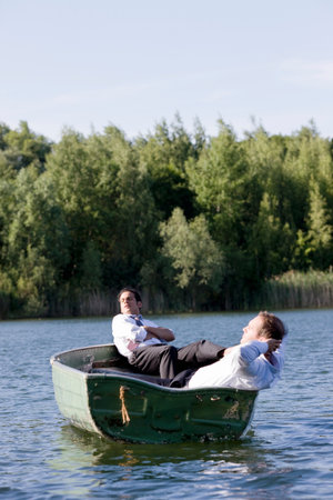 two businessmen relaxing in rowboatの写真素材