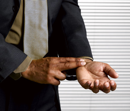 Business man with finger on pulseの写真素材