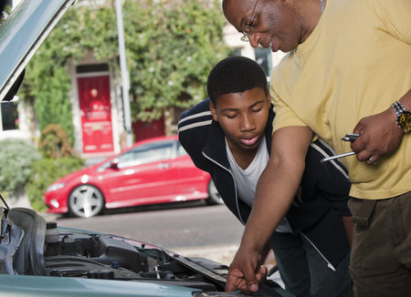 father & son working on car engineの写真素材