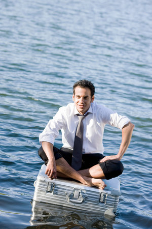 businessman sitting on floating suitcaseの写真素材