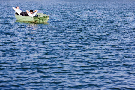 two businessmen relaxing in rowboatの写真素材