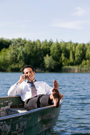 businessman on the phone in rowboatの写真素材