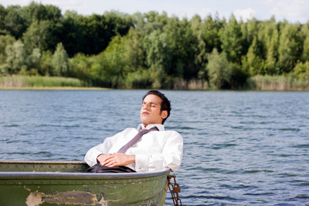 businessman lying in rowboatの写真素材
