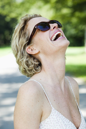 woman with sunglasses laughingの写真素材