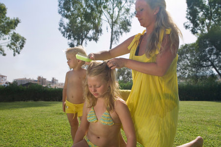 Mother brushing daughter's hairの写真素材