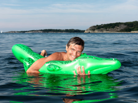 Man with inflatable crocodileの写真素材