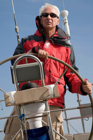 Mature man sailing yacht