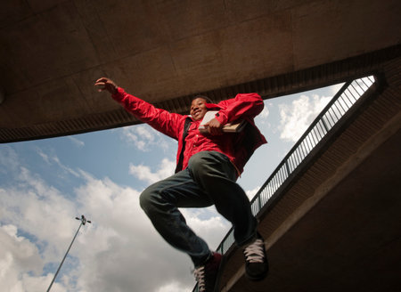 teenage boy jumping with books