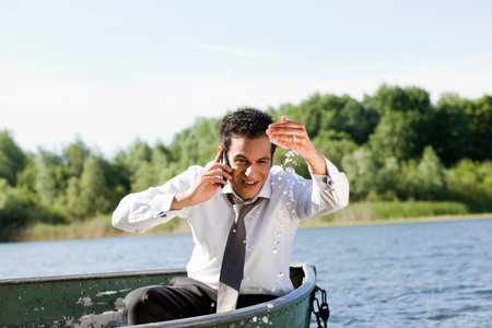 businessman on the phone in rowboatの写真素材
