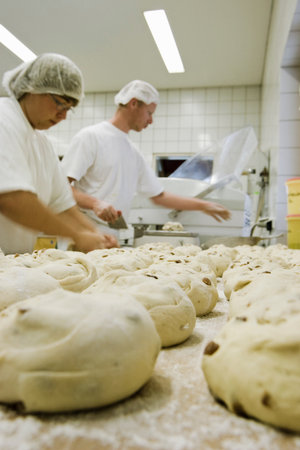 Two people in a bakery with rollsの写真素材