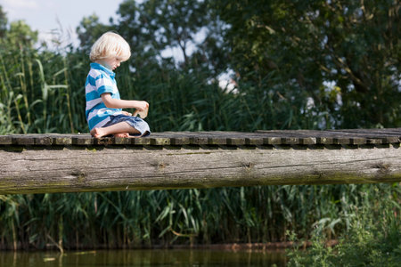 little boy on footbridgeの写真素材