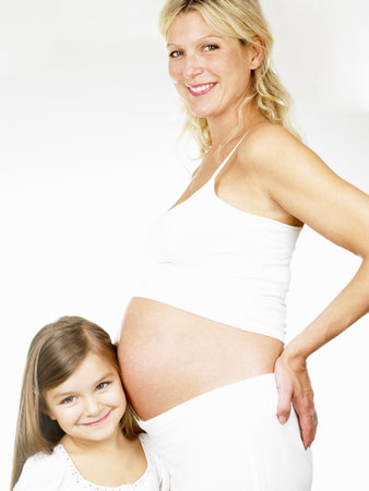 Girl with her pregnant mother, smilingの写真素材