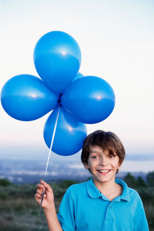 smiling boy with helium balloonsの写真素材