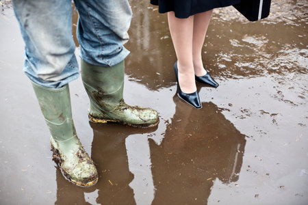business woman with farmer in mud